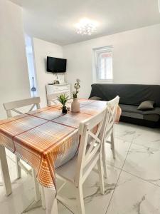 a living room with a table and chairs and a couch at ZARA APARTMENTS in Koper