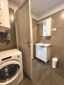 a small bathroom with a washing machine and a sink at ZARA APARTMENTS in Koper