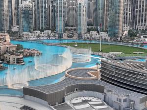 a large water fountain in a city with tall buildings at OSTAY -Address Dubai Mall - The Residence in Dubai