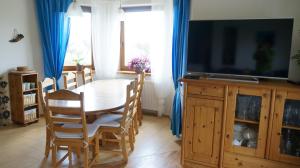 a dining room with a table and a television at Calm House in suburbs of Cracow in Michałowice