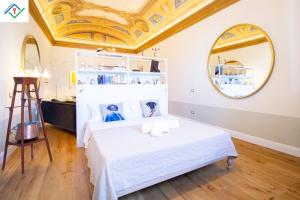 ein Schlafzimmer mit einem weißen Bett und einer goldenen Decke in der Unterkunft Appartamento Orsini in Pisa