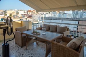 a table and chairs on a balcony with a view at Acropolis Terrace View Apartment in Athens