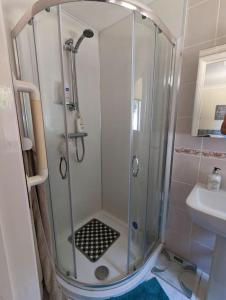 a shower with a glass door in a bathroom at Self-catering guest annex in Norwich