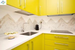 a kitchen with yellow cabinets and a sink at Appartamento Orsini by TuscanyWeGo in Pisa