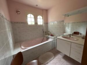 a bathroom with a tub and a sink at la vallee in Plogoff