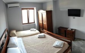- une petite chambre avec 2 lits et une télévision dans l'établissement B&B S Home, à Naples