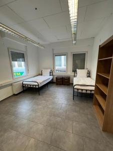 une chambre à l'hôpital avec deux lits et deux fenêtres dans l'établissement Timeless: Einfache 2 Zimmer Wohnung in Ludwigsburg, à Ludwigsbourg