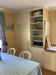 a kitchen with a table and a white cabinet at Parhus i Rönneshytta in Rönneshytta