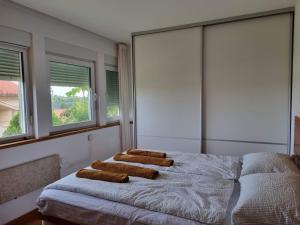 een slaapkamer met een bed met vier kussens erop bij F13 Apartment in Pula