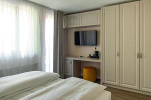 a bedroom with a bed and a desk and a television at Atlantic Boutique in Târgu-Mureş