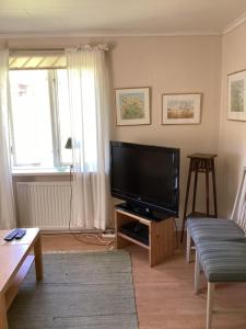 a living room with a flat screen tv on a table at Parhus i Rönneshytta in Rönneshytta