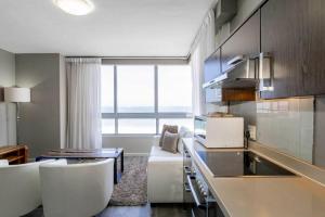 a kitchen with a couch and a table in a room at 801 Infinity 2 Bedroom Beachfront Apartment in Cape Town