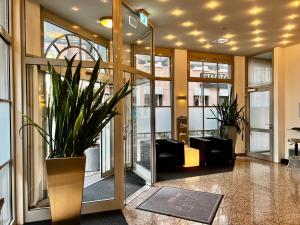 eine Lobby mit Pflanzen in der Mitte eines Gebäudes in der Unterkunft ALFA Hotel - Superior in Karlsruhe