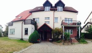 a large white house with a red roof at Fregata in Łeba