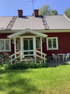 a red house with a picnic table in front of it at Parhus i Rönneshytta in Rönneshytta