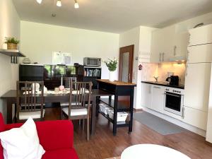 Una cocina y una sala de estar con mesa y sillas. en Haus Land & Meer FeWo14, en Cuxhaven
