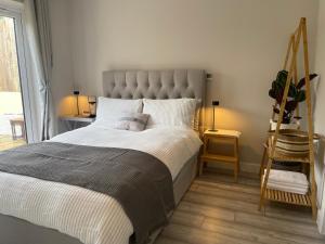 Un dormitorio con una cama grande y una escalera en Cornwall Tranquil Retreats, en Saltash