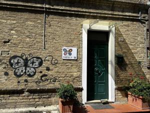 un edificio con una puerta verde y un cartel en él en B&B La Farfalla, en Pescara