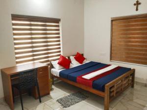 1 dormitorio con cama, escritorio y ventana en Trekkers Villa en Wayanad