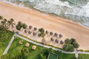 Sheraton Phu Quoc Long Beach Resort في فو كووك: اطلالة علوية على شاطئ فيه مجموعة فيلة