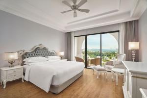 a white bedroom with a bed and a large window at Sheraton Phu Quoc Long Beach Resort in Phu Quoc