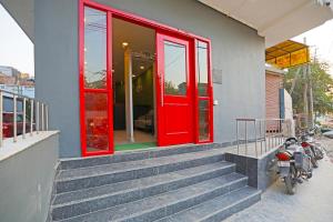 a red door on a building with stairs in front at Hotel Silver Velvet "Britannia Chowk- Couple Friendly Local ID Accepted" in New Delhi