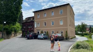 a woman and two children standing in front of a building at Penzion Bamako in Chřibská