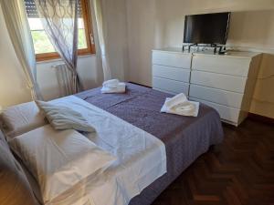 a bedroom with a bed and a dresser with towels on it at Miriam House Florence - full apartment - relax & comfort in Florence