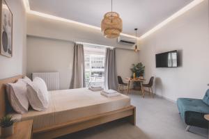 Ederlezi Habitat Apartments في بيرايوس: غرفة نوم بسرير وطاولة مع كراسي