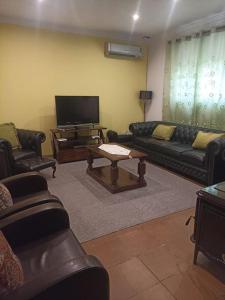 uma sala de estar com sofás e uma televisão de ecrã plano em Villa Girasol em El Arahal