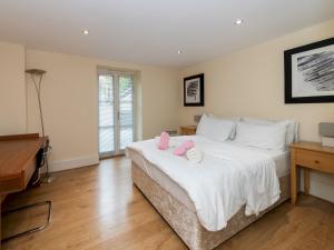 a bedroom with a bed with two dolls on it at Pass the Keys Charming 3 BDR Home close to Reading Town Centre in Reading