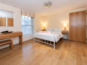 een slaapkamer met een bed, een bureau en een raam bij Pass the Keys Charming 3 BDR Home close to Reading Town Centre in Reading