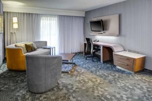 a hotel room with a bed and a desk and a television at Courtyard by Marriott Cleveland Westlake in Westlake