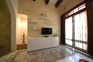 un soggiorno con TV e una grande finestra di Senglea medieval house a Senglea