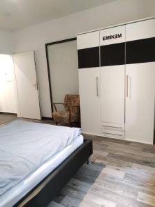 a bedroom with a bed and cabinets and a chair at Wohnung am Waldrand in Melle