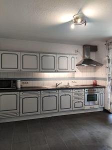 a kitchen with white cabinets and a stove at Wohnung am Waldrand in Melle