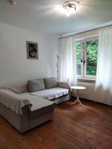 - un salon avec un canapé et une table dans l'établissement Wohnung am Waldrand, à Melle