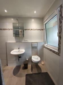 La salle de bains est pourvue de toilettes et d'un lavabo. dans l'établissement Wohnung am Waldrand, à Melle