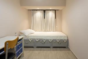 a small bedroom with a bed and a window at Irinis Apartments Karfas, Chios in Chios