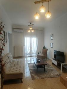 ein Wohnzimmer mit einem Sofa und einem Couchtisch in der Unterkunft Four Reasons Apts Ampelokipi in Thessaloniki