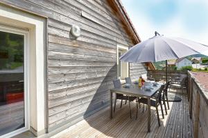 a table with an umbrella on a deck at L'évasion - Charmant appt pour 4 in La Bresse