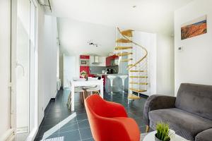 una sala de estar con un sofá y una silla en L'évasion - Charmant appt pour 4, en La Bresse