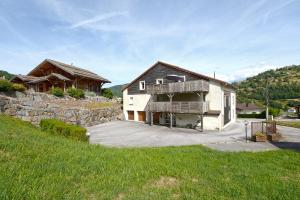 a large house with a stone wall and a yard at L'évasion - Charmant appt pour 4 in La Bresse