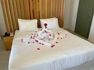 een wit bed met een handdoek en harten erop bij VILLA DI CAPO - Santorini Old Winery Luxury Villas in Akrotiri