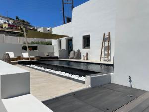 uma casa branca com uma piscina e uma casa em VILLA DI CAPO - Santorini Old Winery Luxury Villas em Akrotírion