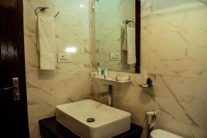 a white bathroom with a sink and a mirror at Hotel Black Diamond - Inside Airport in Kathmandu