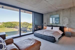 a bedroom with a large bed and a large window at Mi Amor Myoli Beach in Sedgefield