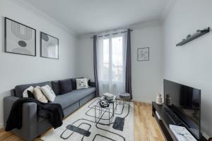 a living room with a couch and a tv at Bundle Famille Max - 12 personnes in La Courneuve
