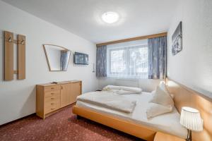 1 dormitorio con 1 cama, vestidor y ventana en Appartmenthaus DeKupi´s, en Sölden