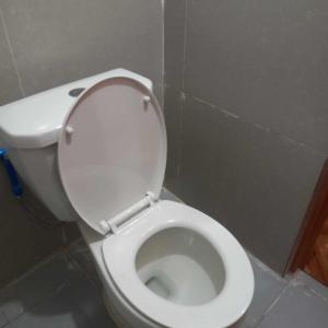 een wit toilet met deksel in de badkamer bij 3rd and try travelers and pension house in Manilla